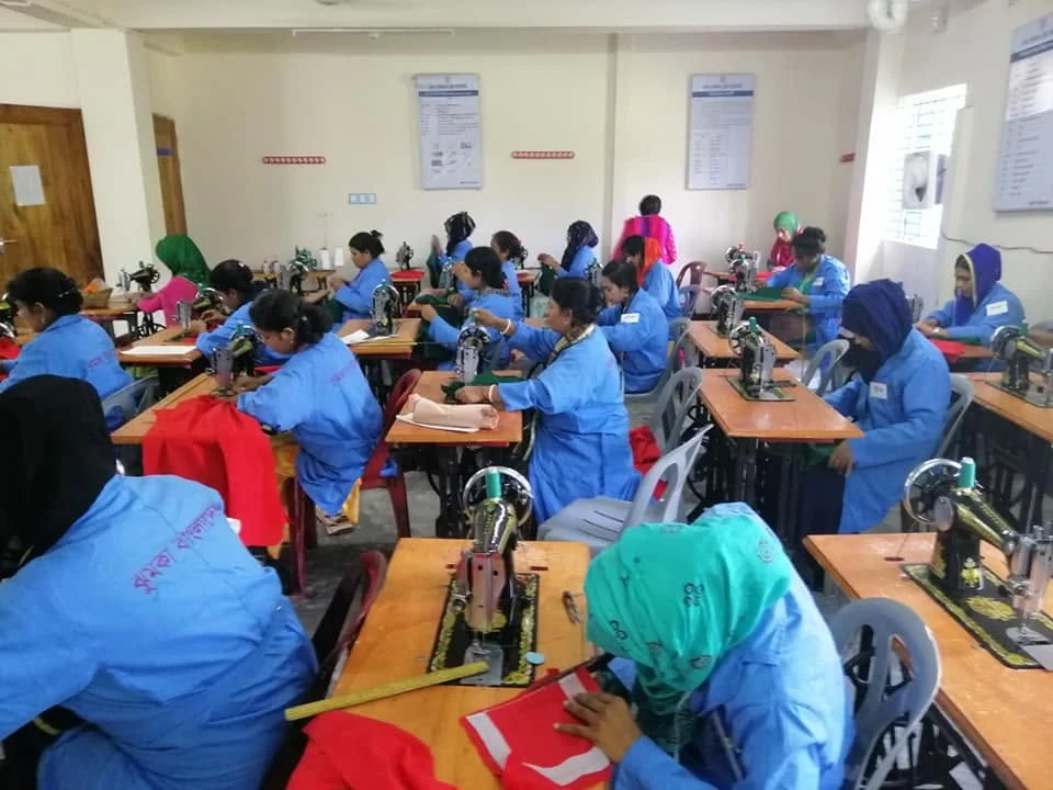 Trainees at their machines during a tailoring course