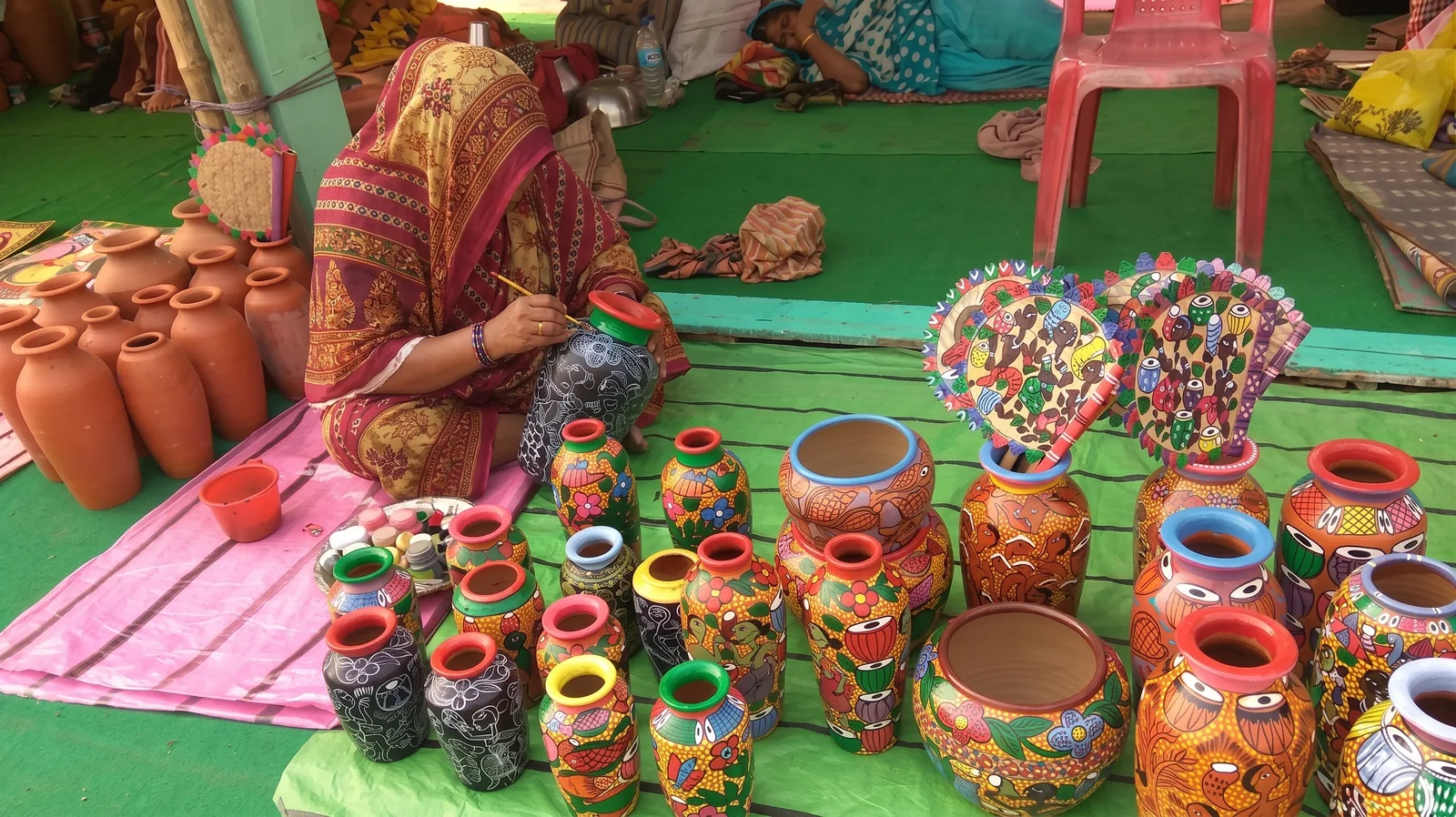 Hand-painted clay pots laid out at a craft fair